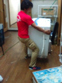 立石が洗濯機を運搬しているところ