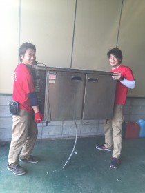 業務用冷蔵庫を持つスタッフ