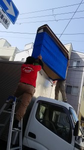 家財道具をトラックの荷台から運び出すところ