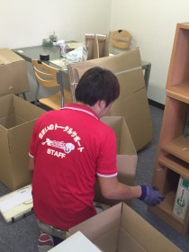 書類などを分別して箱詰めしているスタッフ